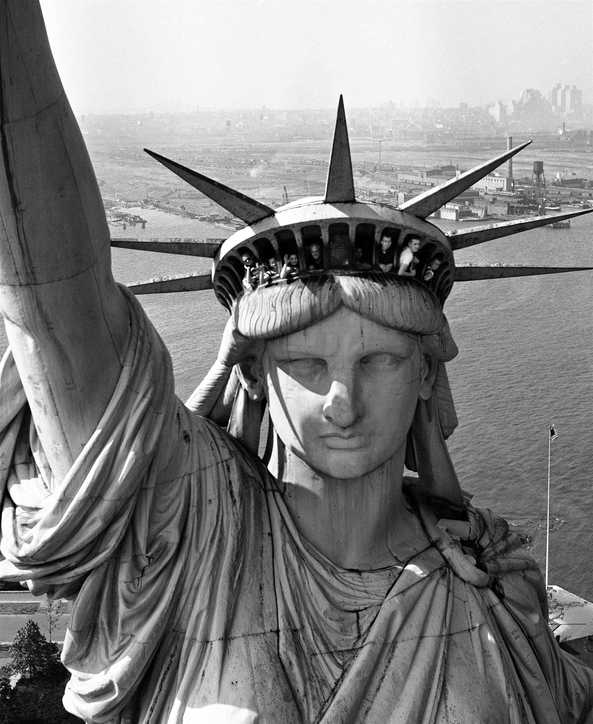 <div>Margaret Bourke-White, <i>Turisti sbirciano dalle finestre della Statua della Libertà</i>, New York City, 1952</div><div>Margaret Bourke-White/The LIFE Picture</div><div>Collection/Shutterstock</div>